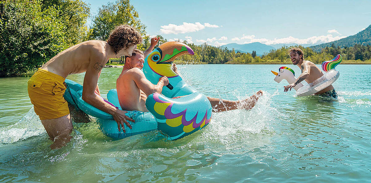 Junge Männer haben Spass im Wasser am Wörthersee