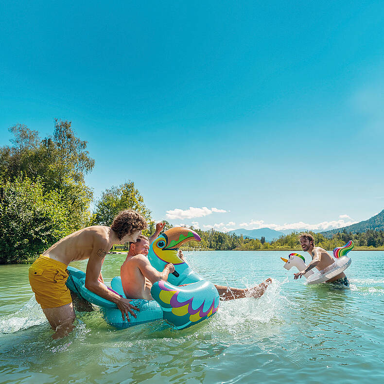 Junge Männer haben Spass im Wasser am Wörthersee