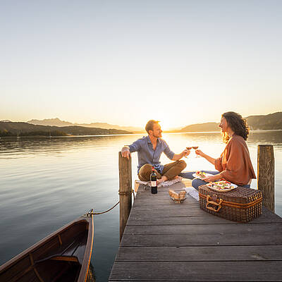 Frau und Mann machen ein schönes Picknick am Wörthersee im Herbst