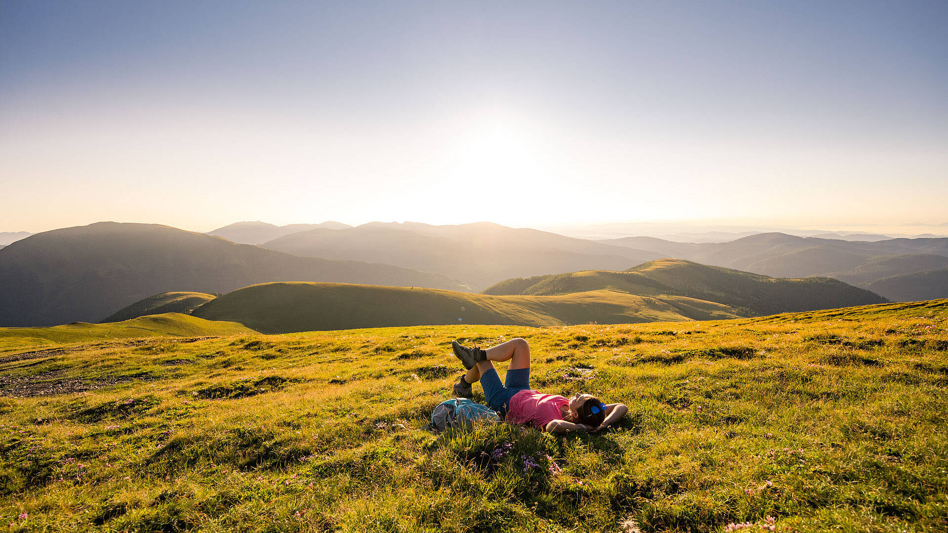 Frau macht eine Pause beim Wandern in den schönen Nockbergen